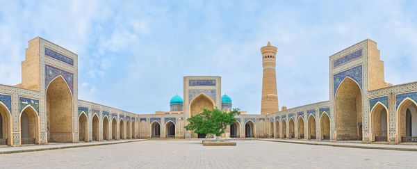 بخارا ازبکستان - 29 آوریل 2015 حیاط بزرگ مسجد کالیان با گنبدهای آبی مدرسه میر عربی و مناره بزرگ در پس زمینه در 29 آوریل در بخارا