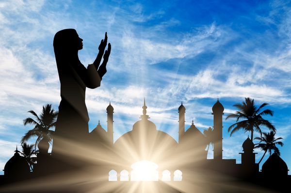 مفهوم دین اسلام شبح نمازگزار زن در پس زمینه تالار شهر در سپیده دم