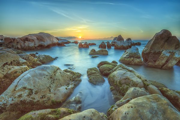 طلوع خورشید بر فراز صخره دریایی بین ثوان با مسیر طلوع خورشید برای تابش زیبای خوش آمدگویی به روز جدید