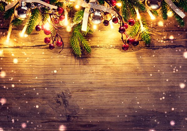 درخت صنوبر کریسمس با تزئین در پس زمینه تخته چوبی تیره طراحی هنر مرزی با درخت کریسمس گلدسته‌ها و گلدسته‌های روشن