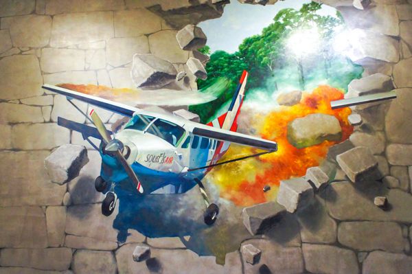 ججو کره جنوبی - 29 نوامبر 2015 نقاشی دیواری سه بعدی هواپیمای در حال سقوط از دیوار آجری سنگی بیرون رانده شد