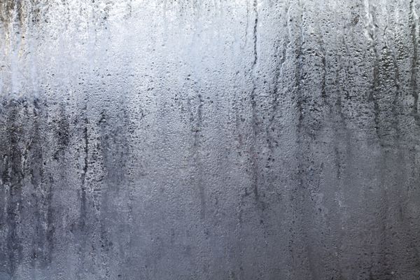 نمای نزدیک از یک پنجره بخار گرفته با قطرات آب ساخته شده در روزهای کسل کننده