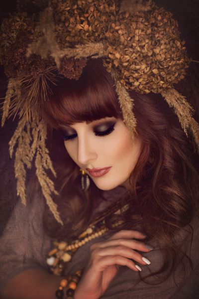 زن جوان زیبا با گلهای خشک روی سر
