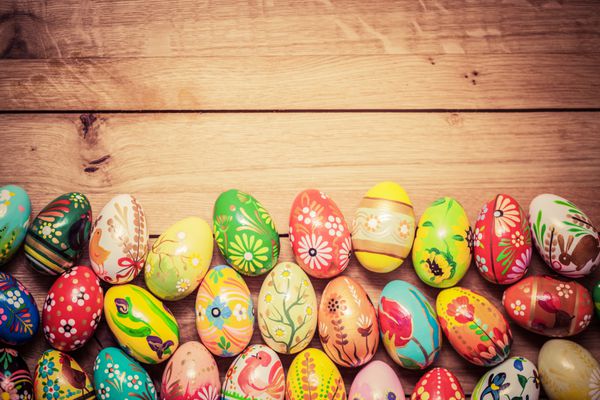 تخم مرغ های رنگارنگ عید پاک روی چوب دکوراسیون سنتی طراحی دست ساز منحصر به فرد قدیمی