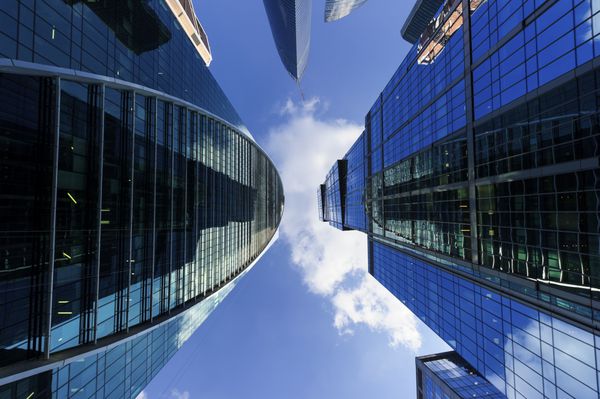 آسمان‌خراش‌های اداری تجاری مدرن نگاه کردن به ساختمان‌های مرتفع در منطقه تجاری معماری بلند شده به آسمان آبی با ابرهای سفید نمای پایین
