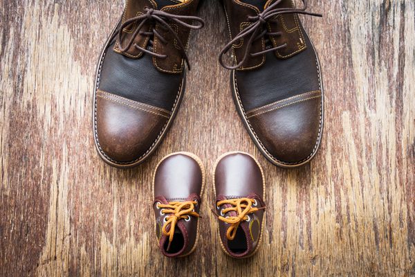 کفش قهوه ای پدر و پسر در زمینه چوبی روز پدر