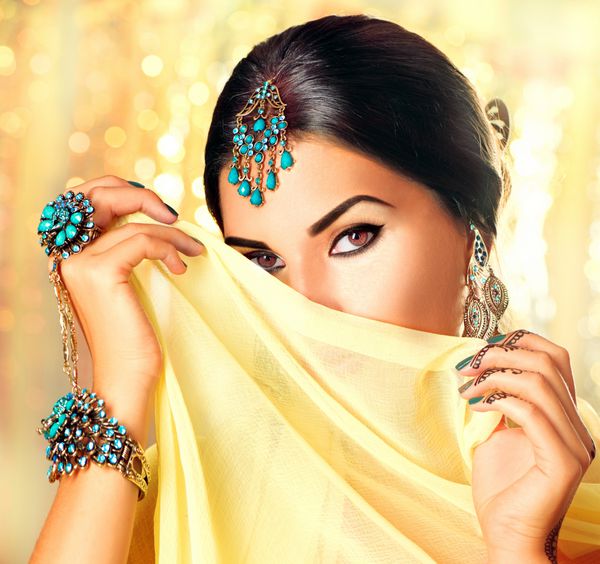 پرتره زن عربی زیبا زن جوان هندو با مهندی از حنای سیاه روی دستانش پرتره مدل هندی زیبایی با آرایش روشن که او را پشت حجاب روی طلا پنهان کرده است