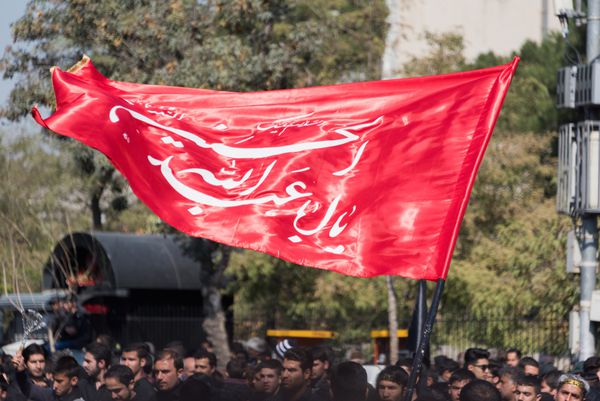 مشهد ایران - 24 اکتبر 2015 شیعیان با پرچم و لباس سیاه در عزاداری شهادت حسین بن علی در ماه محرم در شهر مشهد رژه می روند