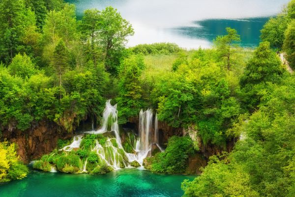 پارک ملی دریاچه های پلیتویس دریاچه ها و آبشارهای شگفت انگیز زمرد احاطه شده توسط جنگل های کرواسی پس زمینه طبیعت مناسب برای کاغذ دیواری یا کتاب راهنما