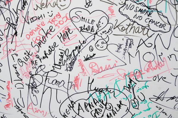بمبئی هند 8 فوریه 2015 افراد ناشناس در طول جشنواره هنری کالا گودا بمبئی پیام و امضا را روی بوم می نویسند و هنر می کنند