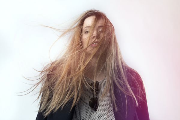 دختری با موهای صاف بلند روی باد سفید استودیویی