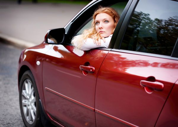 زنی نشسته در ماشین آماده شدن برای رانندگی