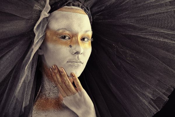 پرتره یک زن هنرمند با رنگ‌های سفید و برنز روی پس‌زمینه سیاه نقاشی شده است پروژه نقاشی بدن