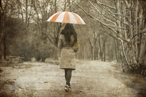 دختر تنها در حال قدم زدن در کوچه در پارک در روز بارانی po به سبک تصویر قدیمی