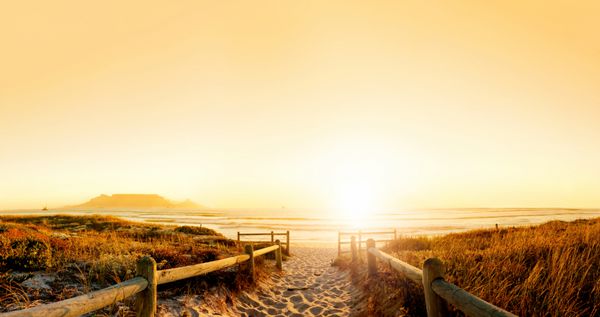 غروب خورشید پانوراما hdr از یک ساحل در نزدیکی کیپ تاون آفریقای جنوبی کوه جدول از دور دیده می شود فایل بسیار بزرگ مناسب برای پس زمینه یا بیلبورد