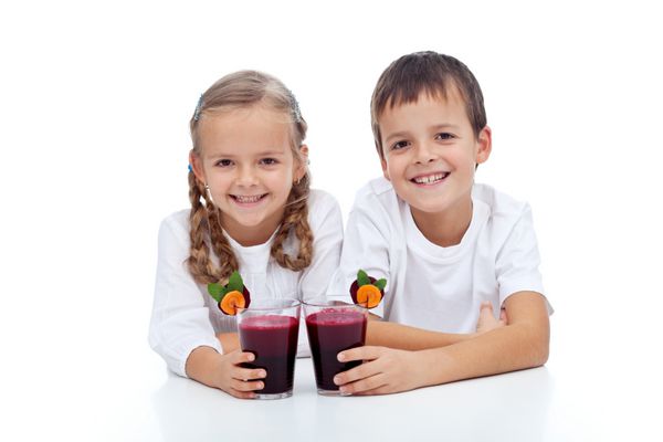 بچه های خندان شاد با آب سبزیجات قرمز تازه فشرده - جدا شده