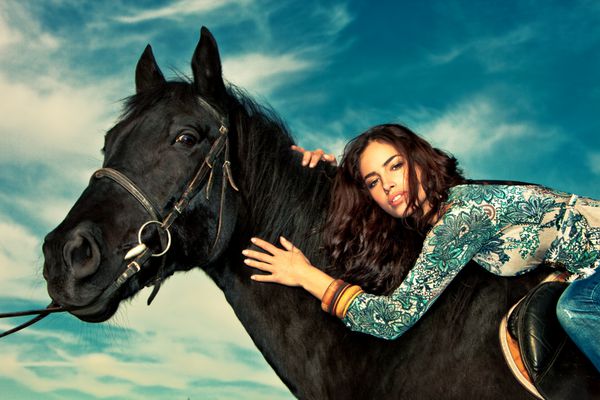 زن جوان زیبا سوار بر اسب پرتره در فضای باز