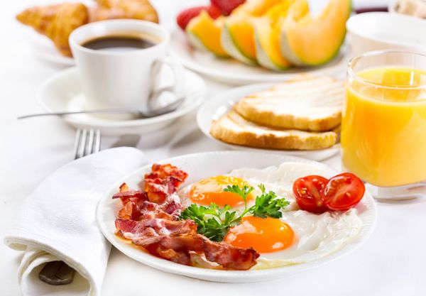 صبحانه با تخم مرغ سرخ شده قهوه آب میوه کروسانت و میوه