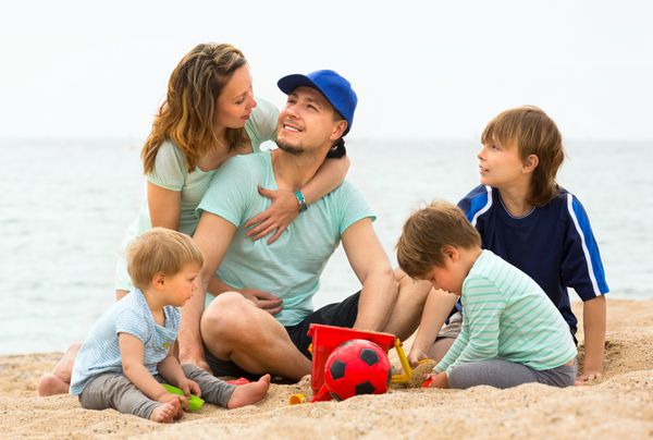 خانواده ای که اوقات فراغت خود را در ساحل می گذرانند