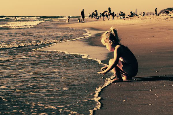 دختری که در ساحل بازی می کند
