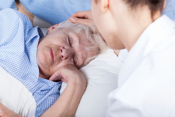 یک پرستار به زن مسن کمک می کند