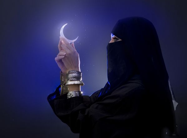 دختر جوان مسلمان زیبا که نماد ماه معنویت را در دست دارد