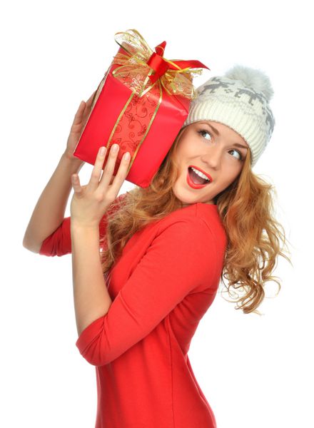 زن هدیه بسته بندی شده کریسمس قرمز را با لبخند در دست دارد