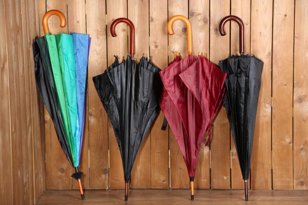 چترهای روشن که به دیوار چوبی تکیه داده اند