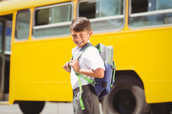 دانش آموز ناز در حال راه رفتن به سمت اتوبوس مدرسه