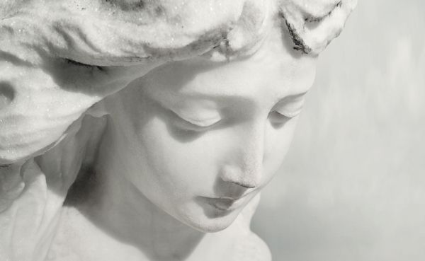 مجسمه مرمری زیبا از نزدیک af af فرشته با بیانی شیرین که به پایین نگاه می کند