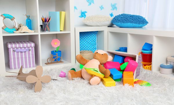 اسباب بازی های رنگارنگ روی فرش کرکی در اتاق کودک