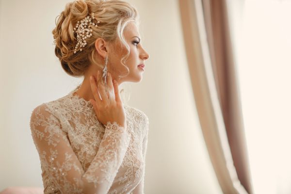 مدل موی آرایش عروسی پرتره عروس زیبا زن جوان زرق و برق دار با لباس سفید در خانه سلسله