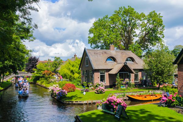 giethoorn هلند - 13 آگوست 2013 گردشگران ناشناس در سفر با قایق در کانال های giethoorn خانه های زیبا و شهر باغبانی به نام ونیز شمال شناخته می شود و بیش از 150 پل دارد