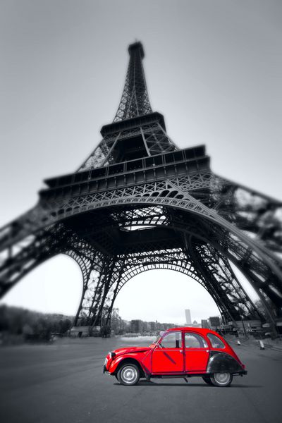 ماشین قرمز قدیمی غروب تابستان در Champ de Mars ایستاده است برج ایفل