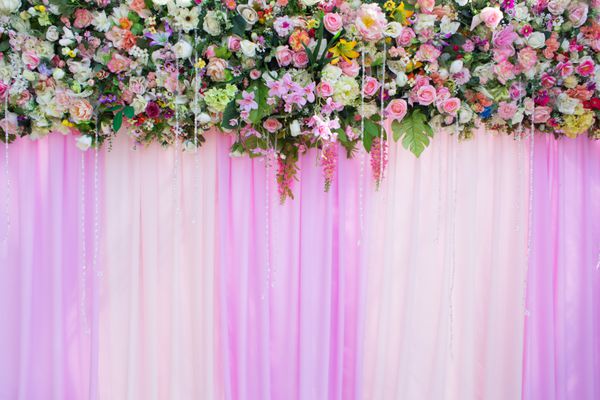 شکوفه گل های زیبا در پس زمینه پرده صورتی برای صحنه عروسی