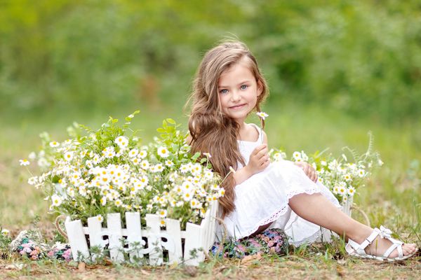 پرتره یک دختر کوچک زیبا با گل