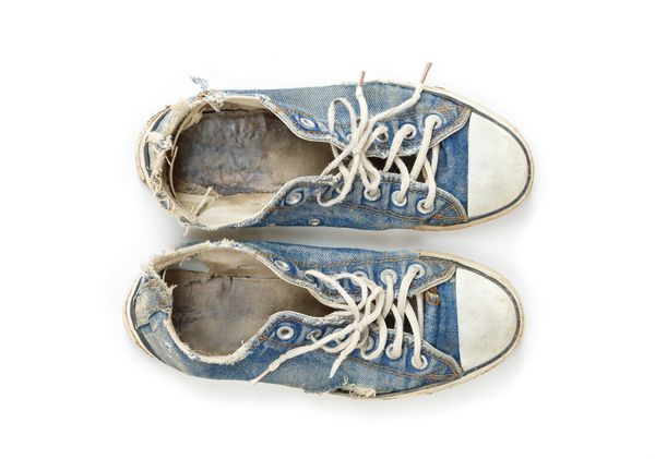 کفش های کتانی بوم آبی قدیمی و کثیف جدا شده در پس زمینه سفید