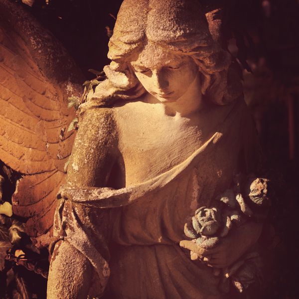 مجسمه سنگی زیبا از نزدیک از افق فرشته با بیانی شیرین که به پایین نگاه می کند قطعه مجسمه