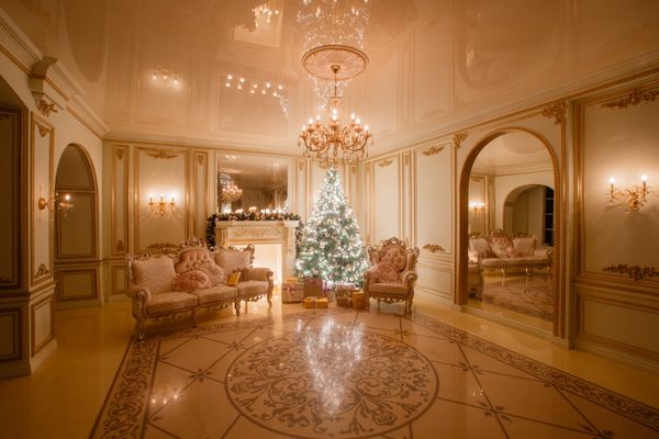 تصویری آرام از درخت سال نو کلاسیک داخلی تزئین شده در اتاقی با شومینه