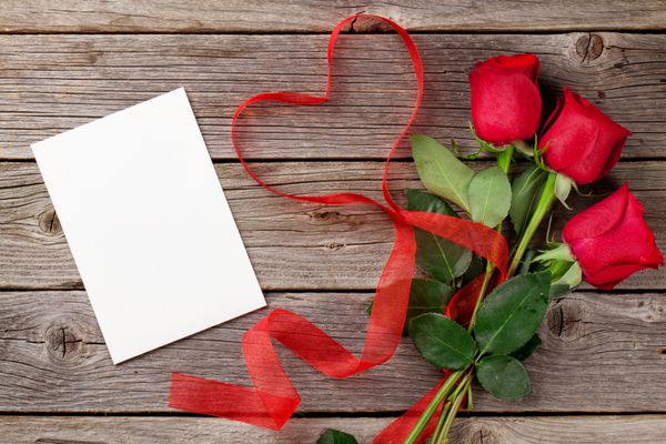گل رز قرمز و کارت تبریک روز در زمینه چوبی نمای بالا با copy sp