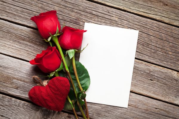 کارت تبریک روز گل های رز قرمز و قلب روی میز چوبی نمای بالا با copy sp