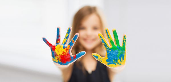دختری که دست های نقاشی شده را نشان می دهد