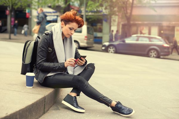 زن جوان با استفاده از تلفن همراه در خیابان زن جوان با استفاده از تلفن همراه در خیابان