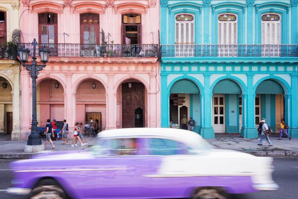 ماشین کلاسیک قدیمی و ساختمان‌های رنگارنگ استعماری در خیابان اصلی هاوانای قدیمی کوبا