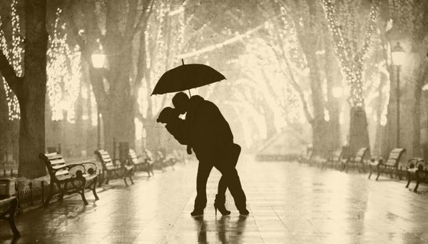 زوج با چتر در حال بوسیدن در کوچه شب