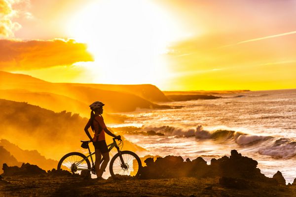 دوچرخه سوار MTB زن دوچرخه سوار در حال دوچرخه سواری به منظره مسیر دوچرخه سواری در ساحل در غروب آفتاب شخصی دوچرخه سوار در کنار دریا با لباس ورزشی با دوچرخه در حال لذت بردن از سبک زندگی سالم فعال در طبیعت زیبا