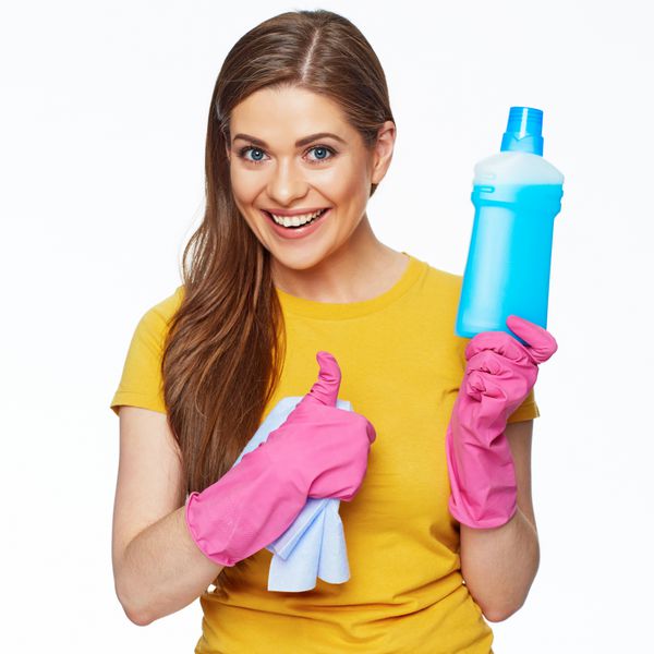 زن خانه دار با در دست داشتن بطری با مایع پاک کننده و نمایش تی