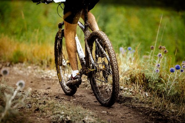 پاهای کثیف ورزشکار دوچرخه سوار ورزشی و دوچرخه سواری کوهستانی پوشیده از گل