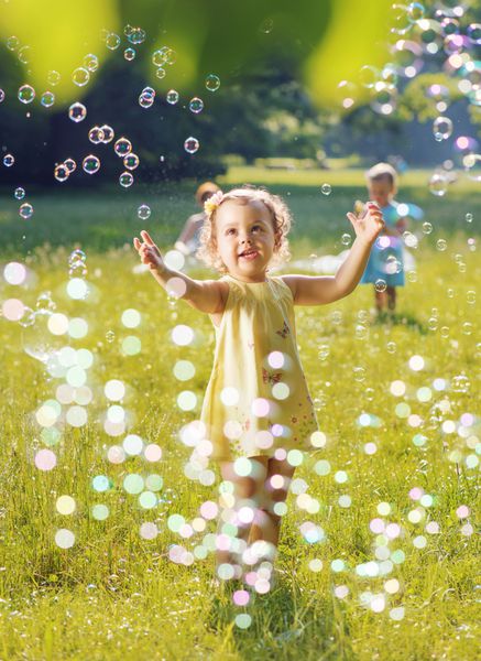 پرتره دو دختر کوچک که با هم حباب های صابون بازی می کنند