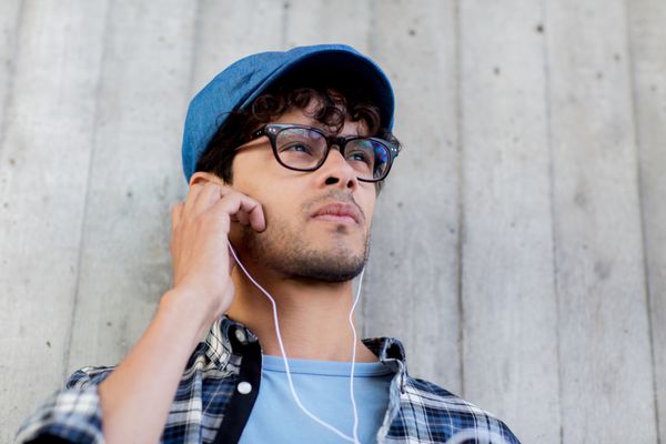 مردی با گوشی در حال گوش دادن به موسیقی در خیابان